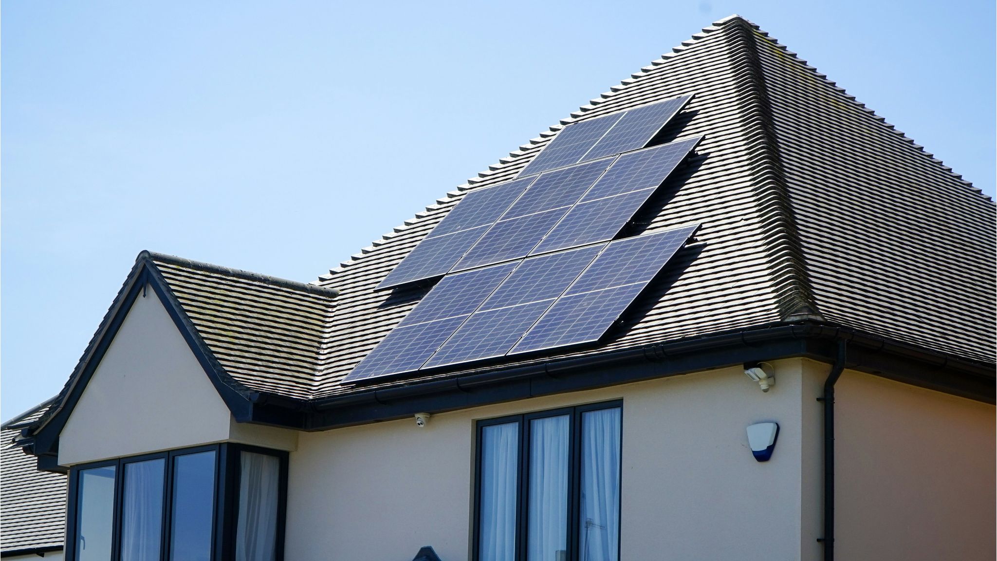[Imagem de uma família feliz na frente de uma casa com painéis solares]