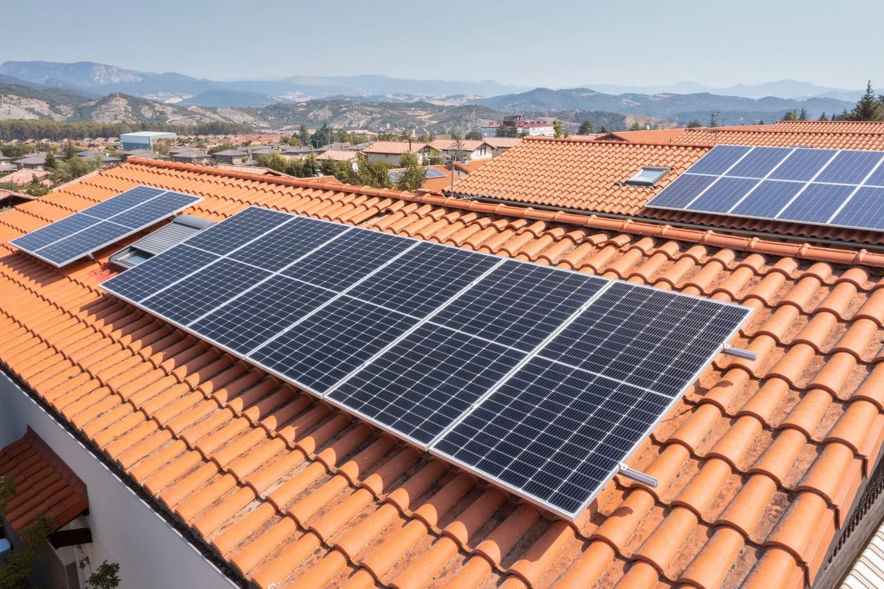 [Imagem de uma casa com painéis solares]